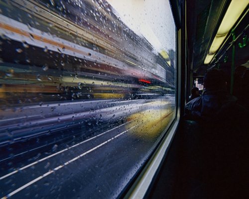 View out the window of a moving bus showing city streets